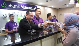 Dirut Muamalat Endy Abdurrahman (kiri) tengah melayani nasabah Bank Muamalat dalam rangka Hari Pelanggan Nasional se-Indonesia.